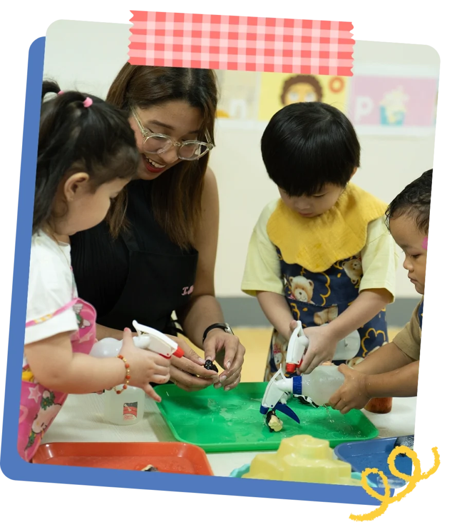 A CPC teacher closely guiding young children through a hands-on glue and craft activity at a classroom table
