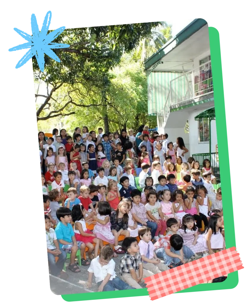 A large group of CPC children and parents gathered together outdoors in the school courtyard during a community event